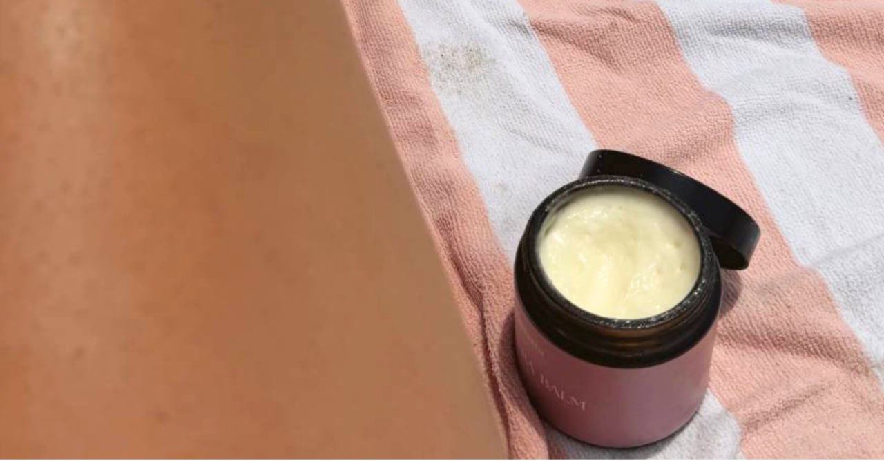 Whipped tallow balm, open on a beach towel